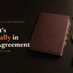 Oxblood sale catalogue and bidder's paddle on dark oak; headline What's Actually in the Agreement