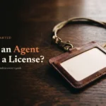 Worn leather badge holder and lanyard on dark oak desk, headline Does an Agent Need a License